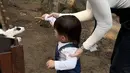 Nikita pun tampil dengan mengikat rambutnya dengan tampilan wajah yang natural ketika memberi makan hewan ternak bersama baby Izz. [Instagram/ @nikitawillyofficial94]