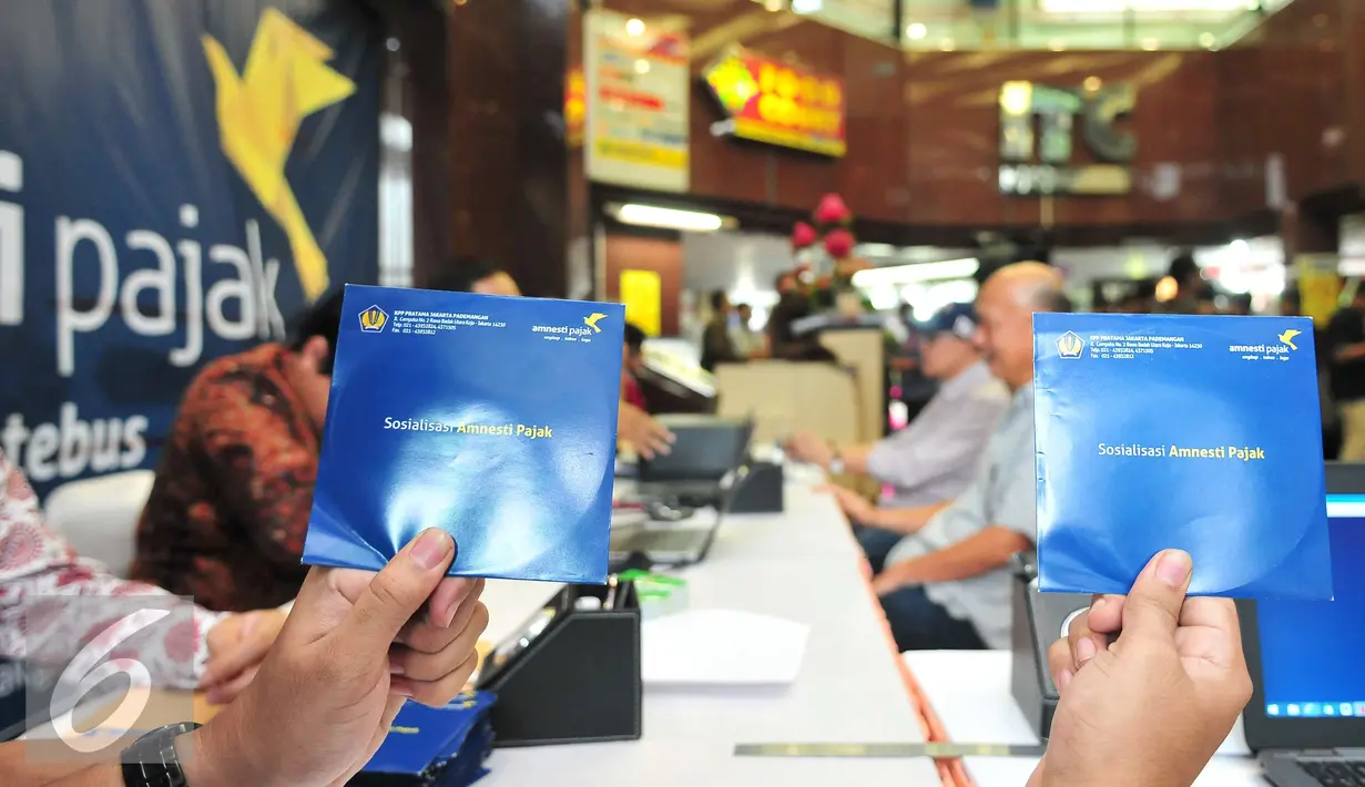 Petugas menunjukan sosialiasi program tax amnesty di ITC Mangga Dua, Jakarta, Selasa (1/11). Dalam sosialisasi itu, Dirjen Pajak mengajak para pedagang dan pelaku UMKM untuk ikut serta program tax amnesty. (Liputan6.com/Angga Yuniar)