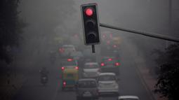 Suasana lalu lintas pada pagi hari saat kabut tebal akibat polusi menyelimuti kota Delhi, India (1/12). Akibat polusi yang amat tebal, banyak warga yang mengeluhkan derita sesak nafas, sakit mata, dan batuk-batuk. (REUTERS/Cathal McNaughton)