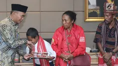 Yohanes “Joni” Ande Kalla menerima penghargaan dan piagam dari Mendikbud Muhadjir Effendy di Jakarta, Senin (20/8). Joni mendapat beasiswa pendidikan atas aksi patriotnya memanjat tiang bendera pada peringatan HUT ke-73 RI. (Liputan6.com/Herman Zakharia)