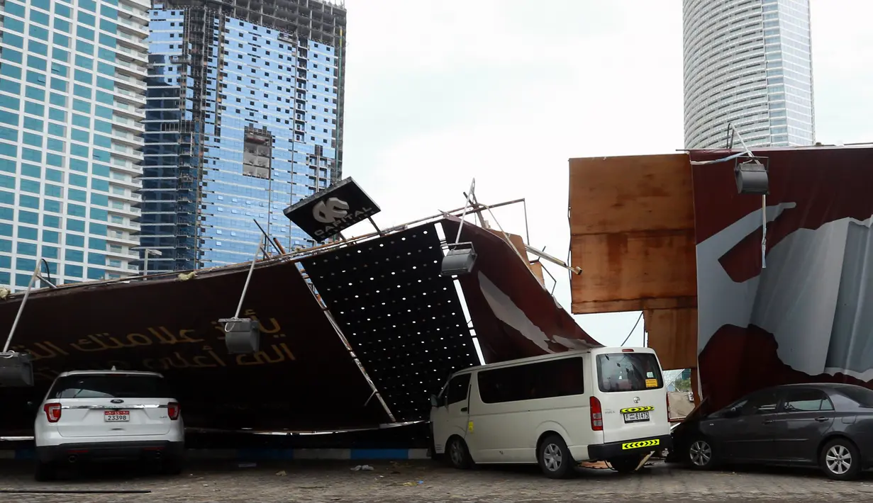 Papan reklame tumbang menimpa sejumlah mobil usai badai hujan, Abu Dhabi (9/3/2016 ). Akibat hujan lebat ini, sekolah diliburkan dan penerbangan ditunda. (AFP Photo)