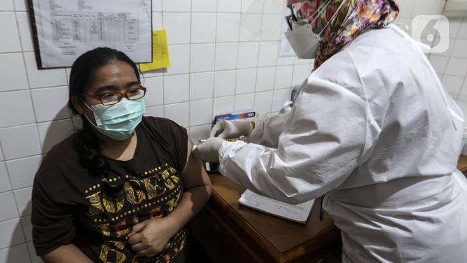 Petugas medis menyuntikkan vaksin COVID-19 Sinovac kepada tenaga kesehatan di Puskesmas Palmerah, Jakarta, Kamis (28/1/2021). Pemberian vaksin COVID-19 tahap kedua dilaksanakan terhadap tenaga kesehatan mulai hari ini. (Liputan6.com/Johan Tallo)