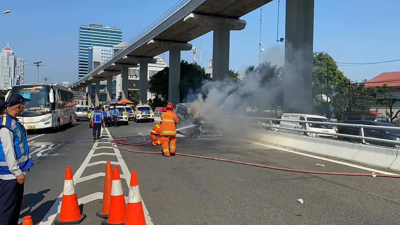 Sebuah mobil terbakar di Kilometer 5, Tol Dalam Kota Jakarta, pada Senin (26/7/2021).