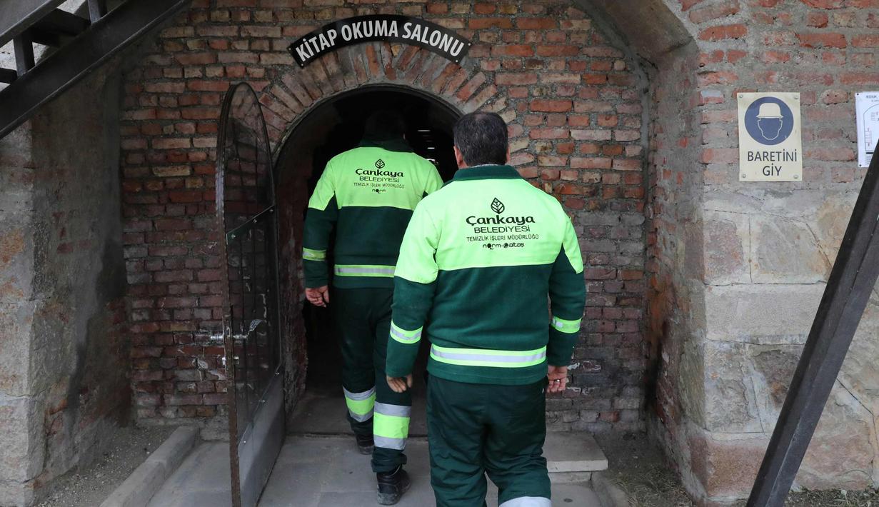 Petugas kebersihan masuk ke perpustakaan saat istirahat di distrik Cankaya, Ankara, Turki 9/1).Beberapa petugas ini membuat band bernama "Grup Tin", dengan menggunakan tempat sampah dan barang bekas sebagai alat musik. (AFP Photo/Adem Altan)