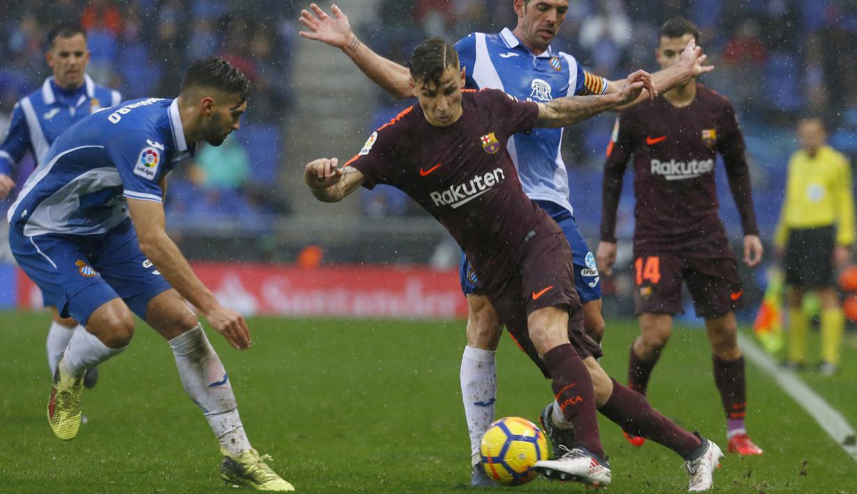 Aksi pemain Barcelona, Lucas Digne (tengah) mencoba melewati adangan para pemain Espanyol  pada lanjutan La Liga santander di RCDE stadium, Cornella Llobregat, Spanyol, (4/2/2018). Espanyol dan Barcelona bermain imbang 1-1. (AFP/Pau Barrena)