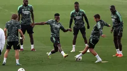 Penyerang Real Madrid, Vinicius Junior (tengah) berusaha merebut bola dari gelandang Eden Hazard selama sesi latihan di kompleks latihan Ciudad Real Madrid di Valdebebas, pinggiran Madrid (13/9/2022). Di partai pertama grup ini, Real Madrid menang 3-0 di kandang Celtic pekan lalu, sementara Leipzig dipermalukan 1-4 saat menjamu tim Ukraina, Shakhtar Donetsk di Red Bull Arena. (AFP/Thomas Coex)
