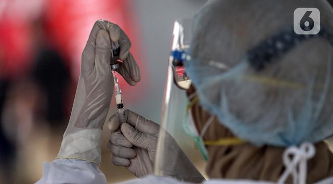 Petugas menyiapkan vaksin COVID-19 saat vaksinasi secara drive-thru di Jalan Duri Raya, Jakarta Barat, Kamis (8/7/2021). Yayasan Cinta anak Bangsa (YACB) Fondation menggelar vaksinasi COVID-19 secara drive-thru dengan menargetkan 800 hingga 1.000 warga ikut vaksinasi ini. (Liputan6.com/Johan Tallo)