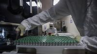 Karyawan bekerja pada mesin pengisi vaksin COVID-19 di Serum Institute of India, Pune, India, Kamis (21/1/2021). Serum Institute of India adalah pembuat vaksin terbesar di dunia dan telah dikontrak untuk memproduksi miliar dosis vaksin AstraZeneca-Oxford University. (AP Photo/Rafiq Maqbool)