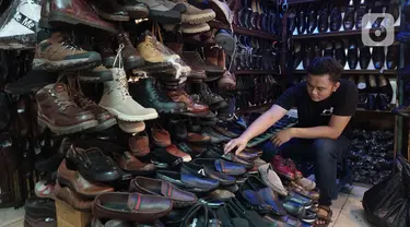 Pedagang tengah menata sepatu yang dijual di Taman Puring, Jakarta,Rabu (21/10/2020). Menurut pedagang penjualan sepatu di lokasi tersebut menurun hingga sebesar 60% akibat sepinya pengunjung di masa pandemi. (Liputan6.com/Angga Yuniar)