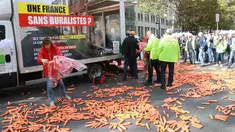 Para penjual tembakau melempar wortel ke jalan saat melakukan aksi protes rencana kenaikan harga sebungkus rokok di Paris, Rabu (4/10). Pemerintah Prancis merencanakan kenaikan harga untuk sebungkus rokok pada 2020 mendatang. (AFP PHOTO/JACQUES DEMARTHON)