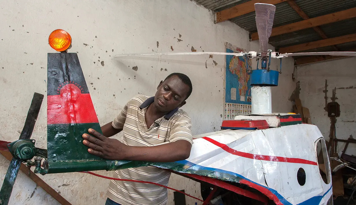 Felix Kambwiri menunjukkan bagian sayap dari helikopter buatannya di garasi rumahnya di Desa Gobede, Malawi, 19 Februari 2016. Helikopter yang dikerjakan sejak empat bulan lalu itu dibuat dari rongsokan besi tua dan fiberglass. (Amos Gumulira/AFP)