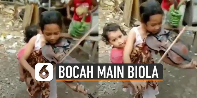 VIDEO: Viral Bocah Gendong Adik Sambil Main Biola