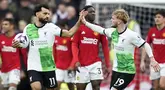 Duel dua pengoleksi utama trofi Liga Inggris, Manchester United dan Liverpool pada pekan ke-32 Liga Inggris 2023/2024 di Old Trafford, Minggu (7/4/2024) malam WIB berakhir imbang 2-2.  Gol penalti Mohamed Salah pada menit ke-84 menggagalkan kebangkitan tim tuan rumah setelah tertinggal lewat gol Luis Diaz (23') namun kemudian memimpin dengan dua gol melalui Bruno Fernandes (50') dan Kobbie Mainoo (67').  Hasil ini membuat Liverpool yang sama-sama mengoleksi 71 poin gagal menyalip Arsenal di puncak klasemen karena kalah selisih gol.  Sedangkan MU dengan 49 poin masih tertahan di posisi 6.  (Foto AP/Dave Thompson)