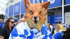Seorang fans Leicester City mengenakan topeng maskot kebanggan Leicester City saat merayakan titel juara Liga Inggris 2015-2016 di Areal Stadion King Power (7/5/2016). (AFP/Glyn Kirk)
