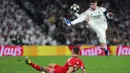 Los Blancos tampil dominan dengan keunggulan yang sudah mereka raih pada pertemuan pertama. Meski demikian, pertandingan berjalan dengan tempo tinggi sejak awal laga. Tampak dalam foto, gelandang Real Madrid asal Uruguay, Federico Valverde (kanan), melompat untuk merebut bola di atas bek SL Benfica asal Swedia, Samuel Dahl, selama pertandingan leg kedua babak playoff 16 besar Liga Champions 2025/2026 di Stadion Santiago Bernabeu pada Rabu 25 Februari 2026 waktu setempat atau Kamis (26/2/2026) dini hari WIB. (Pierre-Philippe MARCOU/AFP)