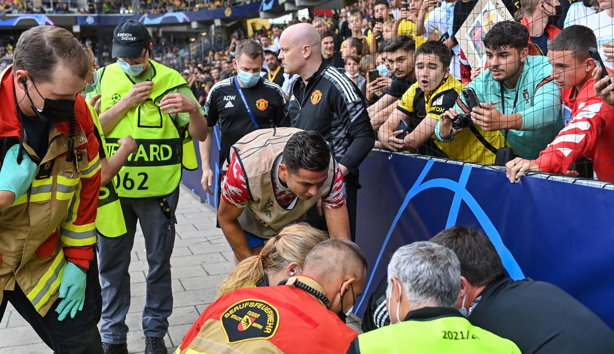 Cristiano Ronaldo yang menyadari tendangan yang dilepaskan mengenai seorang petugas keamanan langsung mendatangi sang petugas dan memberikan uluran tangan padanya. (Foto: AFP/Fabrice Coffrini)