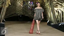 Model membawakan busana rancangan Edward Hutabarat dalam fashion show 'Kenduri' di Senayan City, Jakarta, Senin (15/8). Keunikan fashion show ini ialah ada 'rumah' yang terbuat dari 1.500 bambu. (Liputan6.com/Herman Zakharia)