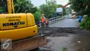 Petugas melakukan perbaikan Jembatan Inspeksi Kali Grogol yang ambles di Komplek Hankam, Slipi, Jakarta, Senin (21/3). Amblesnya jembatan juga akibat pondasi jembatan bergeser dan permukaan jalan amblas. (Liputan6.com/Faisal R Syam)