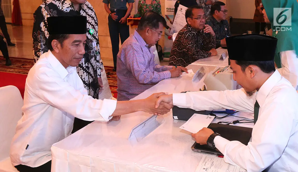 Presiden Joko Widodo bersalaman dengan pengurus Badan Amil Zakat Nasional (Baznas) saat melakukan ijab qobul penyerahan zakat di Istana Negara, Jakarta, Rabu (14/6). (Liputan6.com/Angga Yuniar)