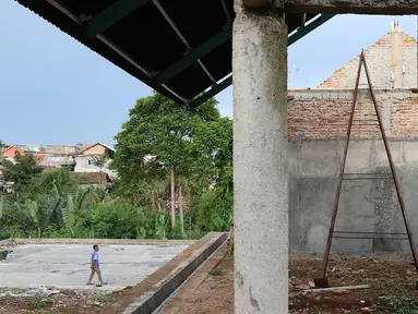 Anak-anak bermain di RPTRA Pelangi Cipedak yang pembangunannya terhenti di Jakarta, Senin (18/3). Terhentinya pembangunan RPTRA yang telah tiga kali mangkrak dikeluhkan warga karena molor dari target yang ditentukan. (Liputan6.com/Immanuel Antonius)