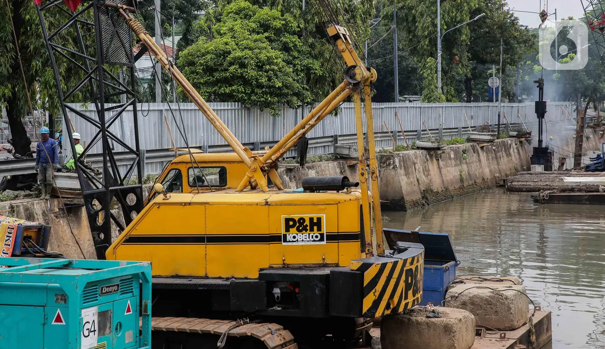 Pekerja menyelesaikan pemasangan dinding turap di kali pasar baru, Jakarta, Rabu (9/3/2022). Dinas Sumber Daya Air DKI Jakarta melakukan pemasangan turap bertujuan untuk mengantisipasi banjir serta tanah ambles di pinggir sungai. (Liputan6.com/Faizal Fanani)