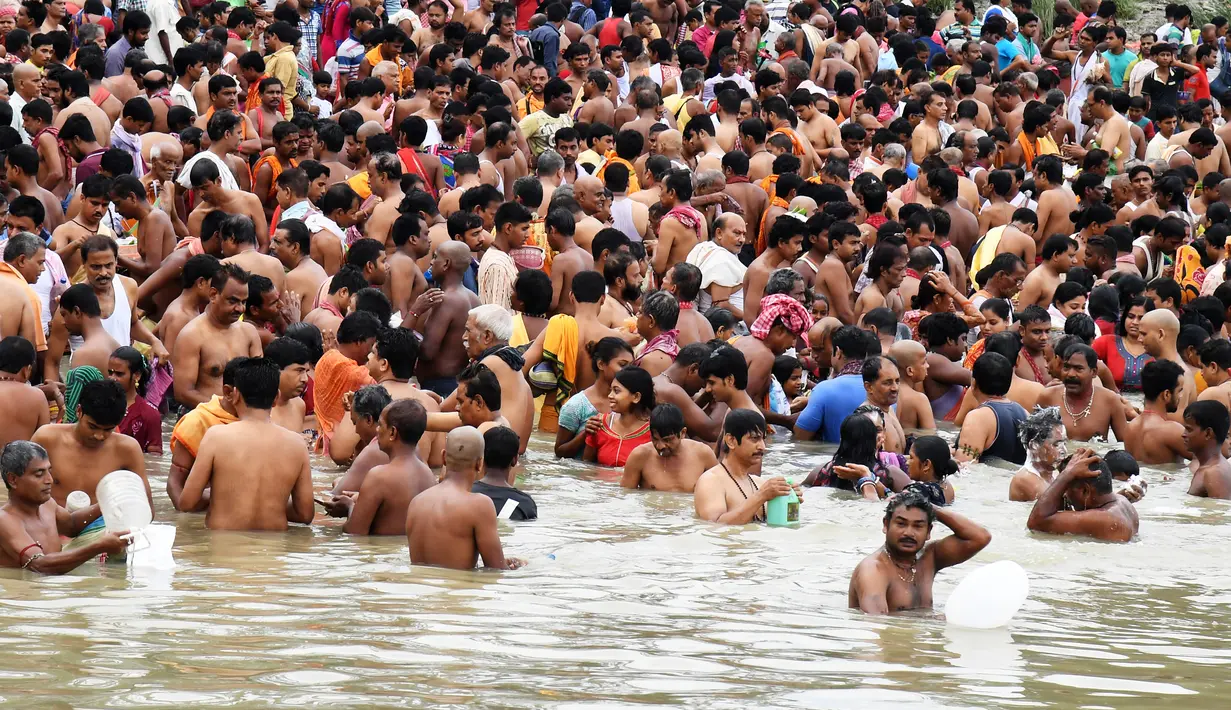 Ratusan umat Hindu berendam di Sungai Gangga melakukan ritual 'Tarpan' untuk memberi hormat kepada nenek moyang mereka pada hari terakhir Pitrupaksh di Kolkata (19/9). (AFP Photo/Dibyangshu Sarkar)