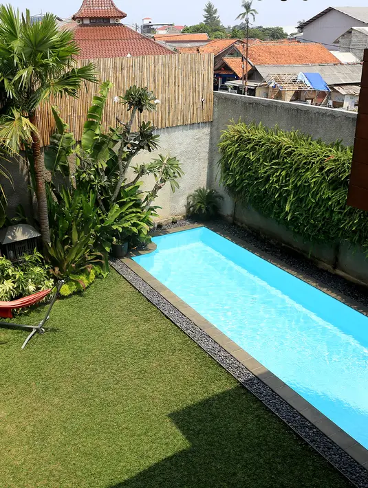 Di samping kolam renang terdapat halaman bermain yang cukup luas serta kursi santai. Teuku Zacky dan Ilmira Usmanova benar-benar mengutamakan kenyamanan buah hati di rumah. (Andy Masela/Bintang.com)