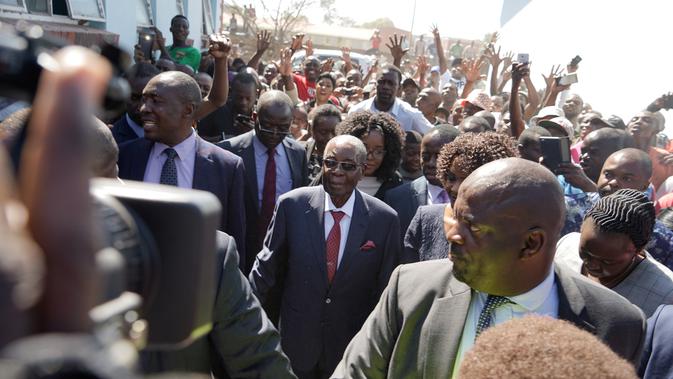 Mantan Presiden Zimbabwe, Robert Mugabe tiba untuk memberikan suara dalam pemilihan umum negara itu di TPS distrik Highfield, Harare, Senin (30/7). Mugabe pertama kalinya menggunakan hak pilihnya setelah dilengserkan November 2017. (AFP/Zinyange AUNTONY)