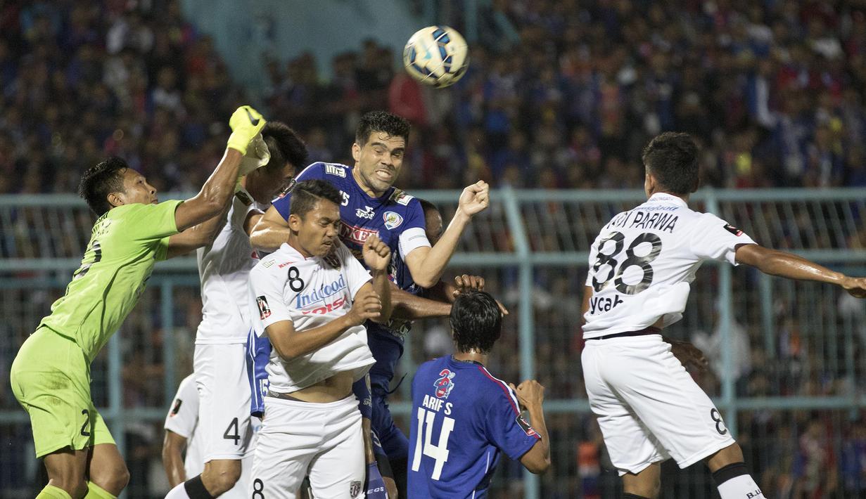 Bek Arema Cronus, Fabiano Beltrame melakukan duel udara dengan kiper Bali United, I Ngurah Komang Aria pada laga perempat final Piala Presiden di Stadion Kanjuruhan, Malang, Sabtu (19/9/2015). (Bola.com/Vitalis Yogi Trisna)