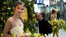 Model tersenyum saat mengenakan gaun berhiaskan bunga-bunga saat berlangsungnya pameran bunga Keukenhof di Central Station di Utrecht, Belanda, (29/3). Pameran ini menghadirkan sekitar 20.000 bunga musim semi. (AP Photo / Peter Dejong)