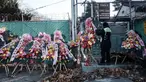 Seorang pekerja publik mengikat karangan bunga buatan dengan pesan-pesan dukungan untuk Presiden Korea Selatan yang dimakzulkan, Yoon Suk Yeol, di Seoul pada Kamis 9 Januari 2025. (Yasuyoshi CHIBA/AFP)