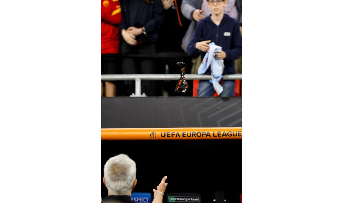 Pelatih AS Roma, Jose Mourinho melemparkan medalinya ke penonton setelah timnya menjadi runner up UEFA Europa League di Puskas Arena, Budapest, Hungaria, 31 Mei 2023. (AFP/Odd Andersen)