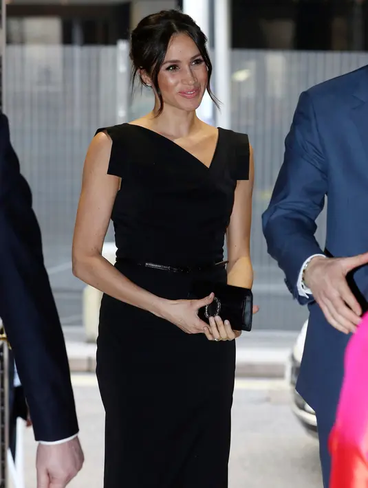 Gaya berbusana Meghan Markle saat menghadiri Commonwealth Heads of Government Meeting di London (19/4). Meghan Markle terlihat mengenakan busana serba hitam dan menenteng tas kecil dari merk fashion terkenal. (Chris Jackson/Pool Photo via AP)