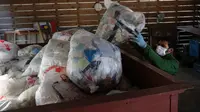 Pekerja mengumpulkan sampah yang telah dipisahkan di pusat limbah di Kamikatsu, Prefektur Tokushima, 14 Maret 2019. Kota di barat daya Jepang ini mengumumkan pada tahun 2003 bahwa pada tahun 2020 akan berhenti menghasilkan limbah sama sekali sebagai tujuan zero waste-nya. (Kazuhiro NOGI/AFP)