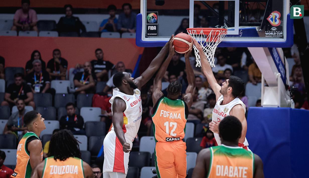 <p>Dua pebasket Spanyol, Usman Garuba (kiri) dan Santiago Aldama melakukan blok kepada pebasket Pantai Gading, Vafessa Fofana pada laga Grup G Piala Dunia FIBA 2023 di Indonesia Arena, Senayan, Jakarta, Sabtu (26/08/2023). (Bola.com/Bagaskara Lazuardi)</p>