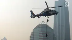 Petugas kepolisian menuruni helikopter menggunakan tali dalam apel pengamanan Asian Games 2018 di Lapangan Ditlantas Polda Metro Jaya, Jakarta, Selasa (31/7). Apel juga diikuti oleh TNI dan instansi terkait. (Merdeka.com/Imam Buhori)