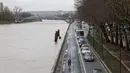 Sejumlah kendaraan melintas di samping sungai Seine yang meluap, Paris, Prancis (5/1). Meluapnya air di sungai Seine akibat tidak mampu menampung debit air setelah hujan terjadi terus-menerus. (AFP Photo/Ludovic Marin)