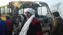 Warga berdiri di samping bus sekolah yang ringsek setelah mengalami tabrakan dengan truk di Etah, negara bagian Uttar Pradesh, India, Kamis (19/1). Bus sekolah itu diketahui mengangkut siswa Aliganj Public School saat tabrakan terjadi. (AFP PHOTO/STR)