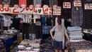 Seorang pedagang pakaian menunggu pembeli di sebuah toko di pasar Namdaemun di Seoul (2/7/2019). Pasar ini sangat populer bagi para wisatawan asing yang berkunjung ke Seoul. (AFP Photo/Minji Suh)
