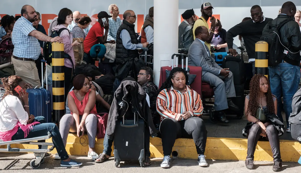 Penumpang tidak dapat memasuki terminal keberangkatan Kenya Airways setelah pemogokan pekerja maskapai di Bandara Internasional Jomo Kenyatta, Nairobi, Rabu (6/3). Aksi itu menyebabkan ratusan penumpang terlantar di bandara. (Yasuyoshi CHIBA/AFP)