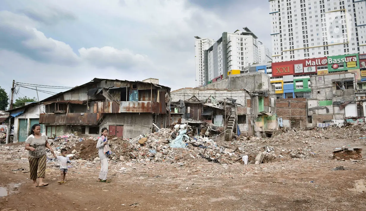 Warga melintasi lahan yang dahulunya permukiman yang terkena gusuran proyek Tol Becakayu, Cipinang Besar Utara, Jakarta, Senin (30/12/2019). Tercatat 900 rumah warga di 3 RW, yakni RW 001, 002, dan 003 Kelurahan Cipinang Besar Utara terkena gusuran proyek Tol Becakayu. (merdeka.com/Iqbal S. Nugroho)