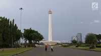 Dua warga beraktivias di kawasan Monumen Nasional (Monas), Jakarta, Sabtu (19/5). Kawasan wisata yang menjadi simbol ibukota tersebut menjadi salah satu lokasi warga untuk “ngabuburit” atau menunggu waktu berbuka puasa. (Liputan6.com/Immanuel Antonius)