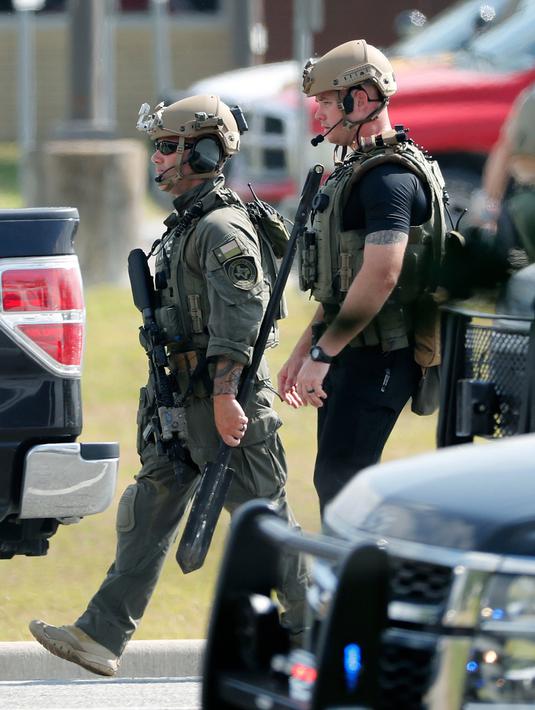 Polisi dengan peralatan taktis bersiaga usai penembakan di Santa Fe High School, Texas, AS, Jumat (18/5). Gubernur Texas Greg Abbot mengatakan tersangka menggunakan senapan dan pistol kaliber 38. (Kevin M. Cox/The Galveston County Daily News via AP)