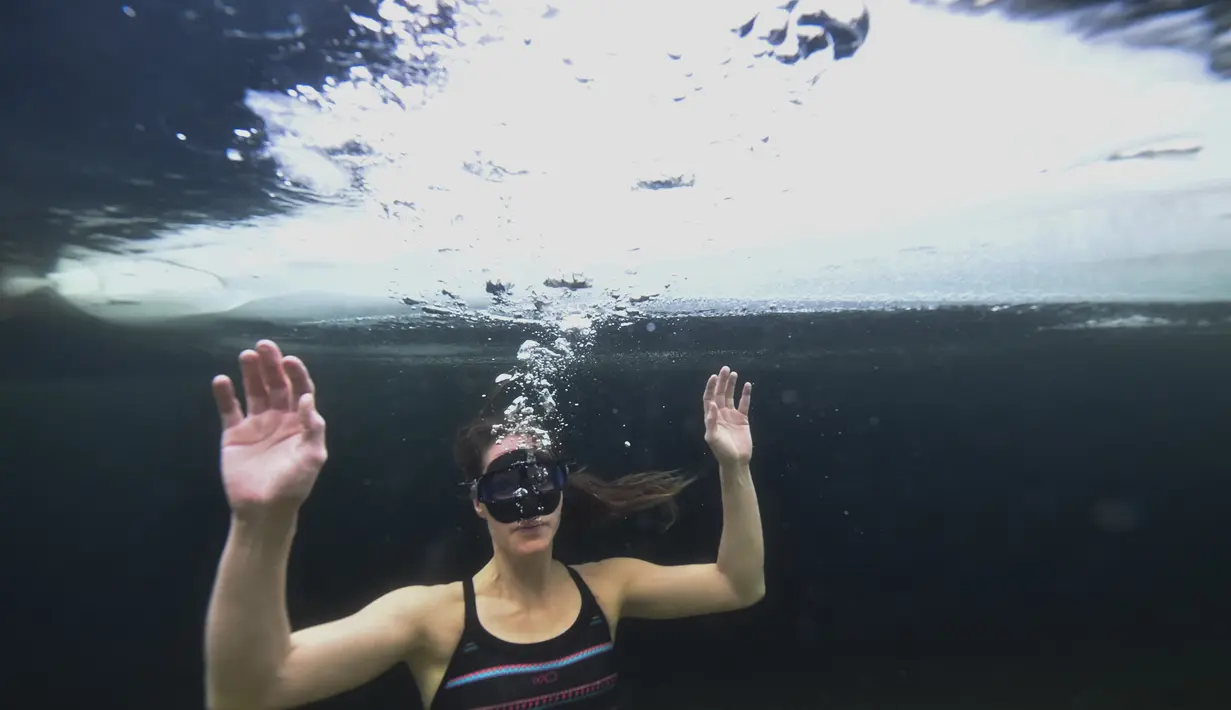 Johanna Nordblad menyelam di danau beku, Somero, Finlandia, Selasa (27/2). Johanna Nordblad memegang rekor dunia freediving di bawah es dengan baju renang sejauh 50m. (AFP PHOTO / Olivier Morin)