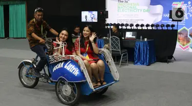 Dua wanita menaiki becak listrik selama pameran pada Hari Listrik Nasional di JCC, Jakarta, Rabu (9/10/2019). HLN ke-74 mengusung tema "Keberlanjutan Sektor Ketenagalistrikan dalam Menghadapi Era industri 4.0". (Liputan6.com/Angga Yuniar)