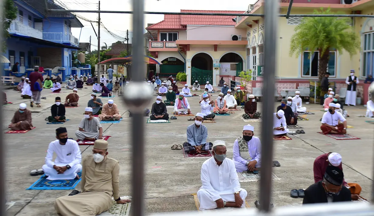 Umat muslim melaksanakan salat Idul Fitri dengan mengenakan masker di halaman Masjid Yakaniah, Narathiwat, Thailand, Minggu (24/5/2020). Idul Fitri tahun ini dirayakan umat muslim seluruh dunia di tengah pandemi virus corona COVID-19. (Madaree TOHLALA/AFP)