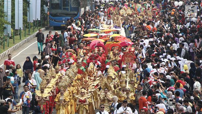 Warga menyambut antusias pawai obor Asian Para Games 2018 ketika melintas di kawasan Jakarta, Minggu (30/9). Asian Para Games akan dilaksanakan pada 6-13 Oktober 2018 mendatang. (Liputan6.com/Herman Zakahria)
