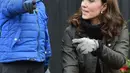 Kate Middleton berbincang dengan anak-anak saat mengunjungi Sekolah Dasar Robin Hood di London, Inggris (29/11). Middleton tampil cantik mengenakan jaket berwarna cokelat dengan rambut terurai. (AFP Photo/Pool/Eddie Mulholland)