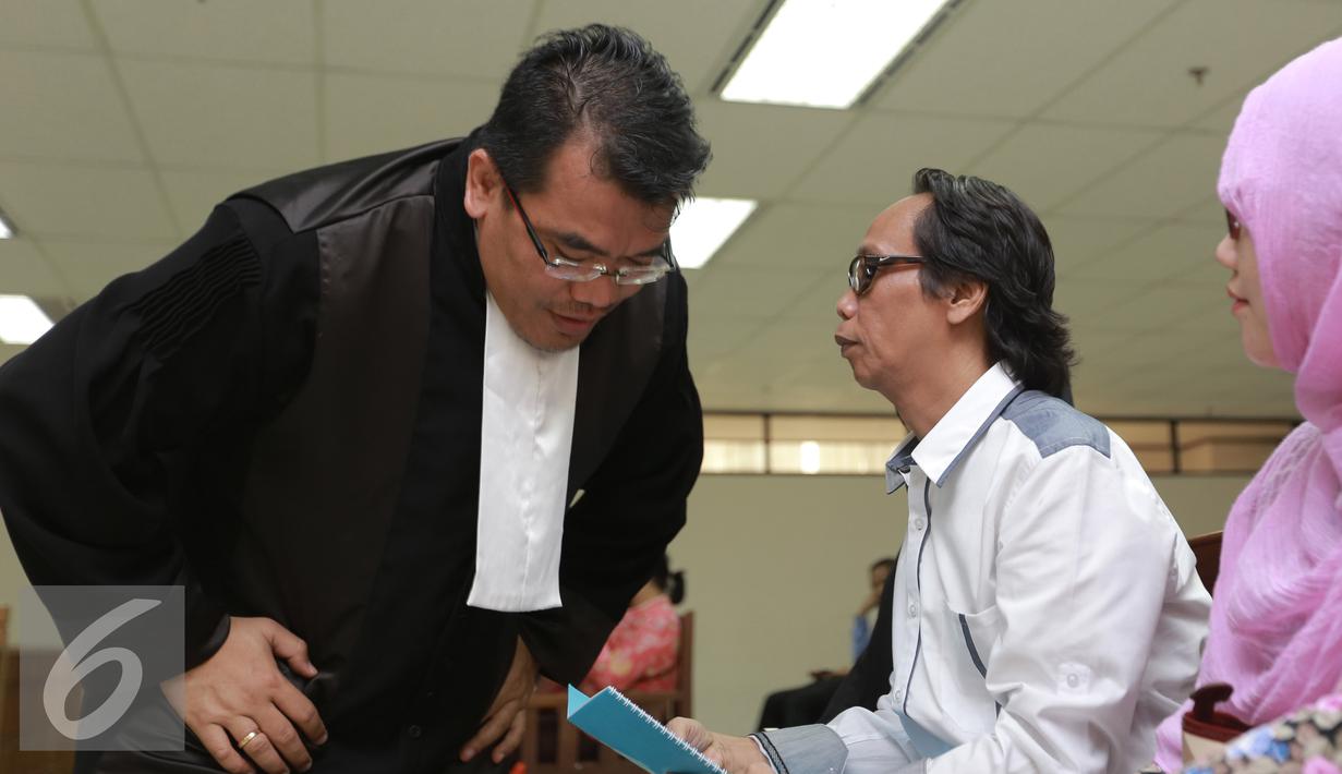 Mandra Naih (kanan) saat berbincang dengan kuasa hukumnya sebelum  menjalani sidang lanjutan di Pengadilan Tipikor, Jakarta, Senin (31/8/2015). Sidang ini beragendakan pembacaan eksepsi atau nota keberatan dari terdakwa. (Liputan6.com/Herman Zakharia)