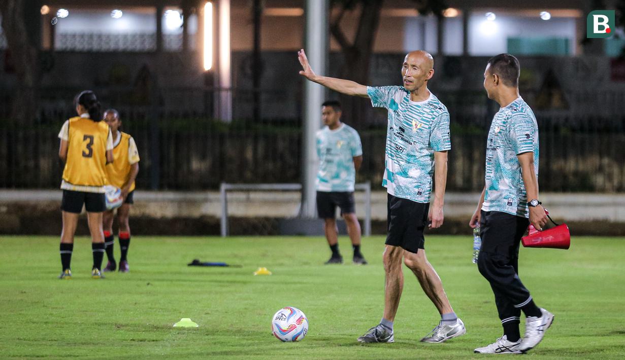 <p>Pelatih Timnas Indonesia Putri U-17, Satoru Mochizuki berbincang dengan asistennya saat memimpin latihan Timnas Indonesia Putri U-17 yang berlangsung di Lapangan A Kompleks Stadion Utama Gelora Bung Karno (SUGBK), Senayan, Jakarta, Rabu (27/03/2024). Latihan tersebut merupakan bentuk persiapan untuk Piala Asia U-17 yang bergulir di Bali pada 6-19 Mei 2024. (Bola.com/Bagaskara Lazuardi)</p>